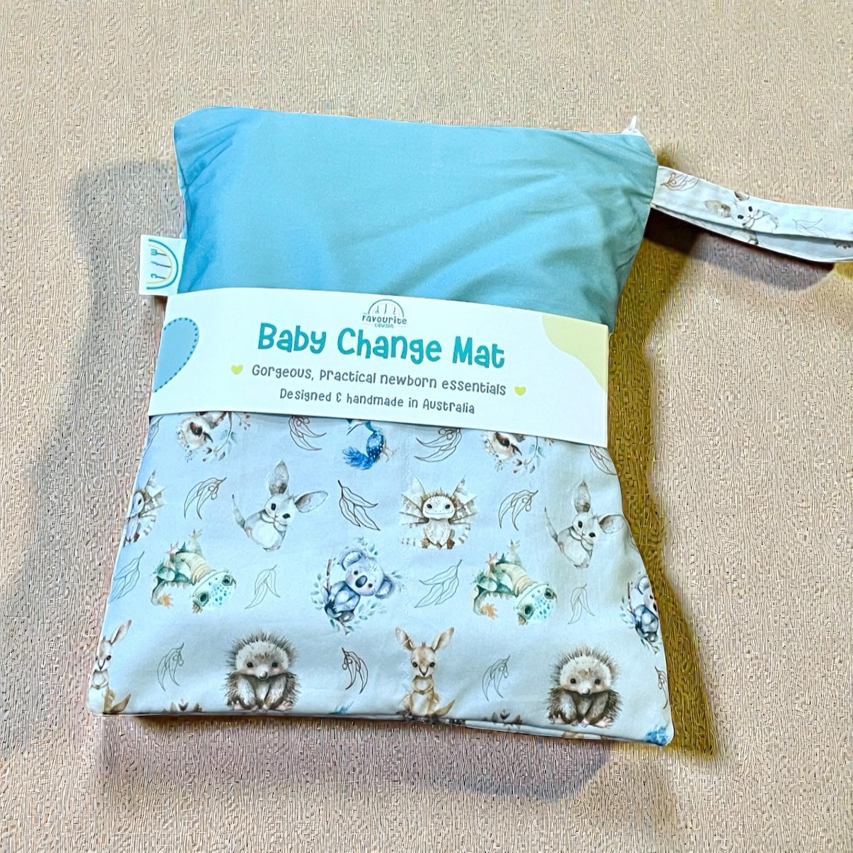 Baby change mat with aussie animal patterns on a beige surface