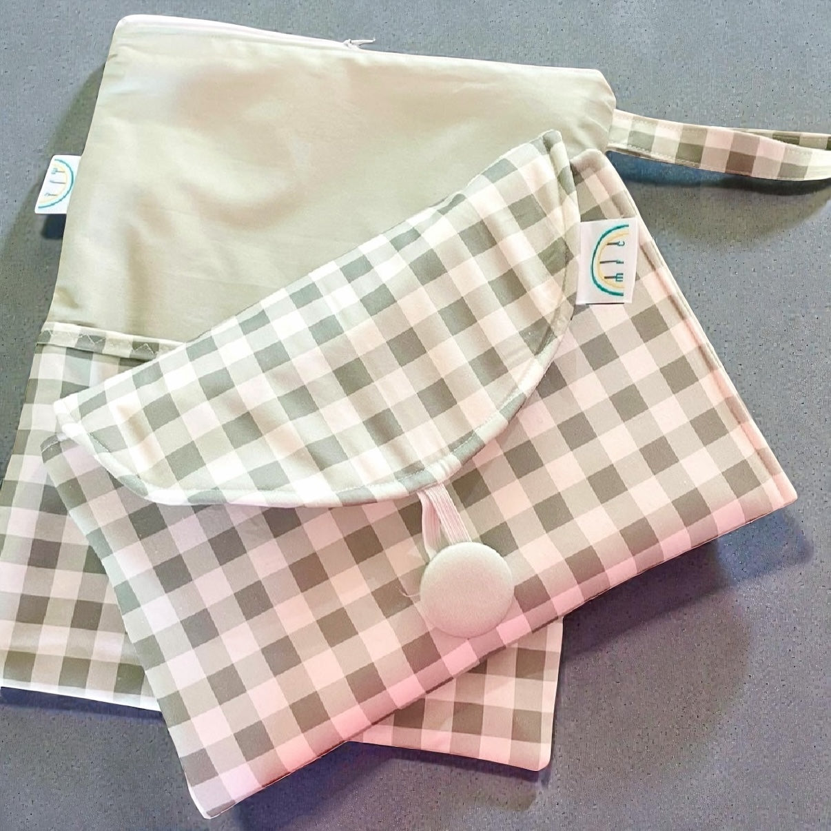 folded change mat and storage bag in sage green gingham fabric