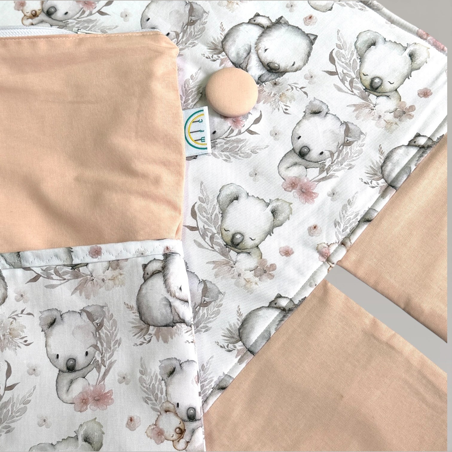 change mat with large peach button and koala wombat print