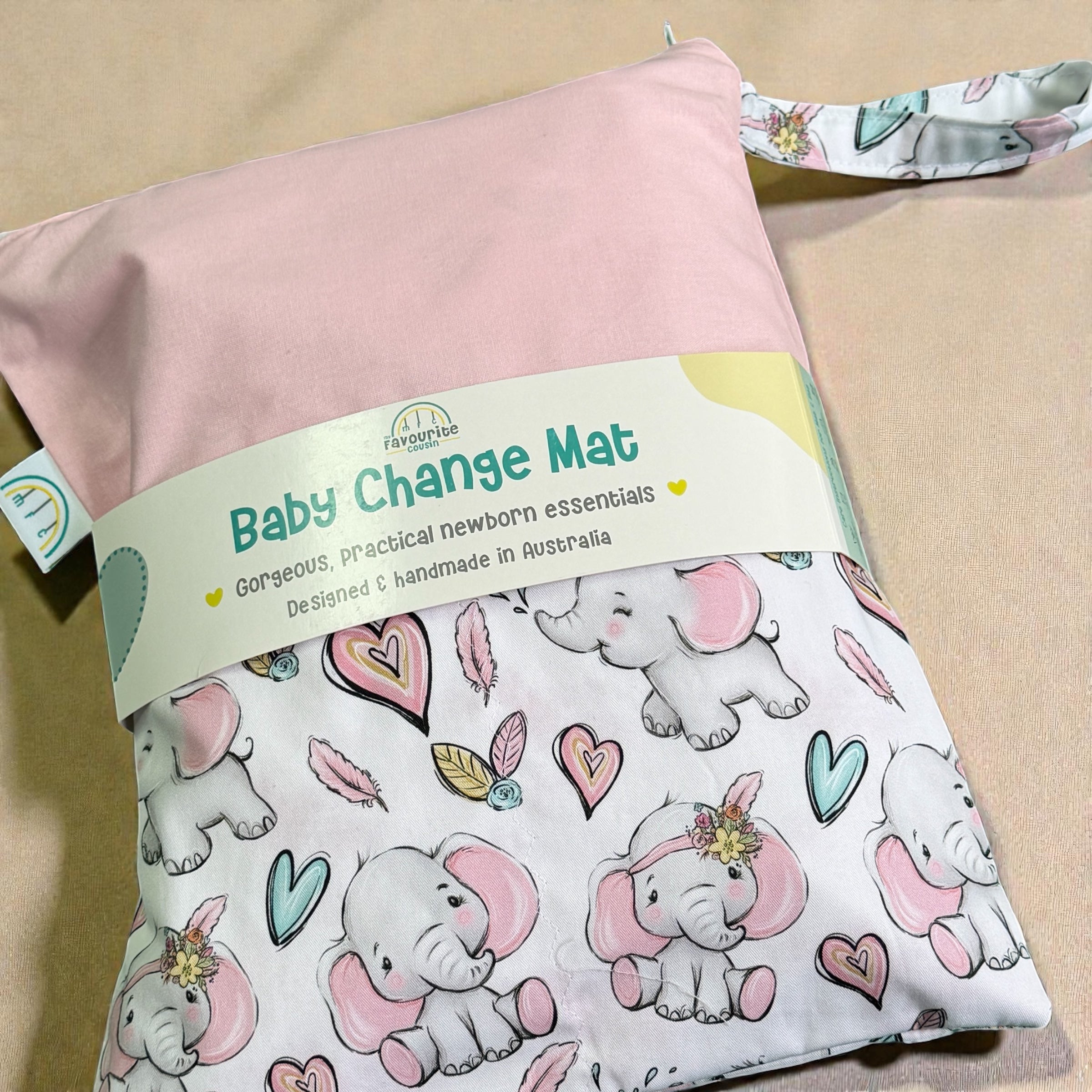 Baby change mat with pink elephant pattern and pink cover on a white background