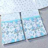 baby change mat showing 2 pockets attached to the mat wiht blue elephants on a gray background