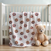 Crib with a floral-patterned blanket and a teddy bear on a wooden floor.