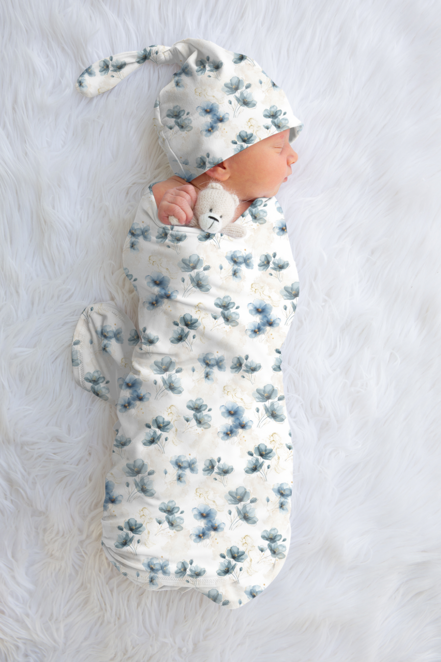 Sleeping baby wrapped in a blue floral swaddle 