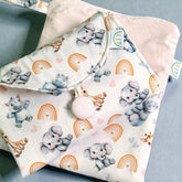 pink Baby change mat with elephant hippo and rainbow pattern on a light blue surface