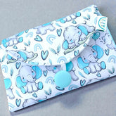 folded Baby change mat with elephant pattern on a gray background