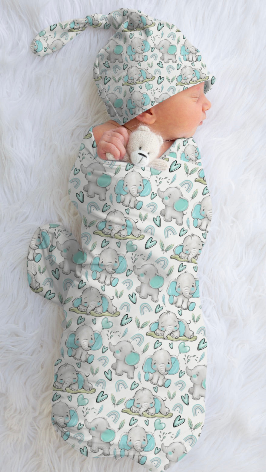 A baby swaddled in a blanket with blue elephant fabric design.