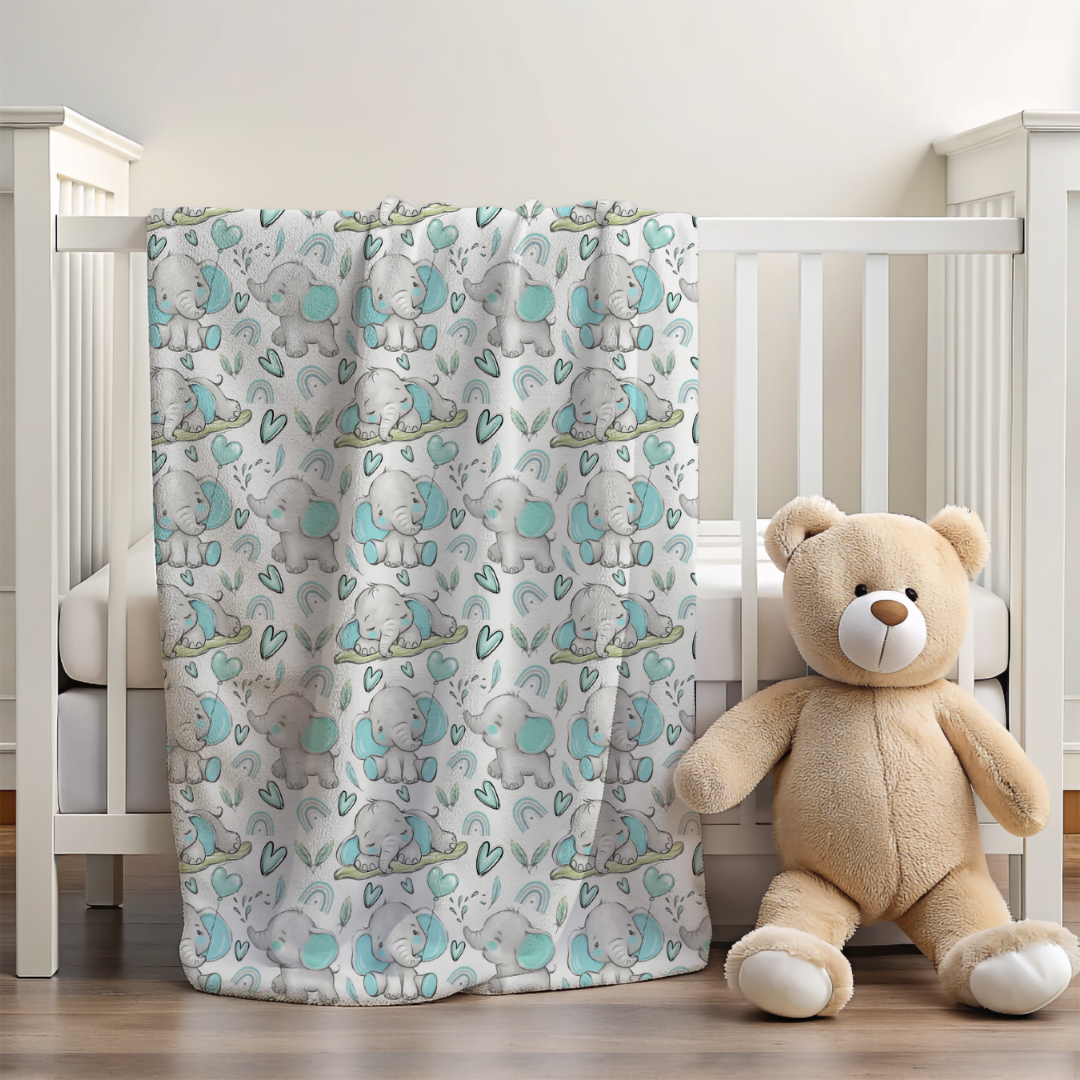 blanket with blue and grey elephants with hearts over the side of a cot with a small teddy 